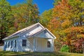 A little white church under blue skies surrounded with fall leaves. Royalty Free Stock Photo