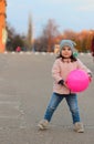 little white girl playing with a ball on the street in the evening. Portrait on the background of the sunset cityscape Royalty Free Stock Photo