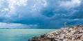 Little white house on the end of sea beach walkway and beautiful dark clouds background at Khao Lam Ya, Rayong, Thailand. Royalty Free Stock Photo