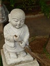 Little white stone monk statue sweeping the floor