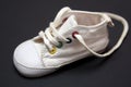 Little white untied little baby shoe on black background Royalty Free Stock Photo