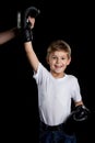 The little winner. Extremely happy little boxer with right hand up in black boxing gloves