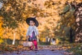 little witch on autumn forest background. Helloween costume children party Royalty Free Stock Photo