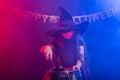 Little witch child cooking potion in the cauldron on Halloween. Royalty Free Stock Photo