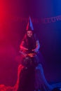 Little witch child cooking potion in the cauldron on Halloween. Royalty Free Stock Photo