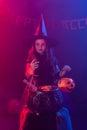 Little witch child cooking potion in the cauldron on Halloween. Royalty Free Stock Photo