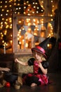 Little witch in costum and hats conjure pot, childhood hallowee Royalty Free Stock Photo