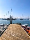 Little wood pier with small abandoned boat and Sailing boat on the background during blue sky day