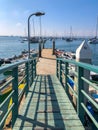 Little wood pier with small abandoned boat and Sailing boat on the background during blue sky day