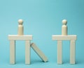 Little wooden men stand on the destroyed bridge on different sides on a blue background