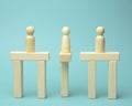 Little wooden men stand on the destroyed bridge on different sides on a blue background