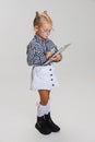 Cropped side view portrait of cute little girl in casual clothing and stylish glasses isolated over gray background Royalty Free Stock Photo