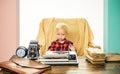 Little writer work on book at desk. Boy writer type on vintage typewriter in office