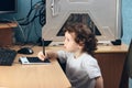 Little 2 3 year old baby girl in white clothers draws at the home computer in graphics drawing tablet. The child is holding a pen Royalty Free Stock Photo