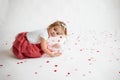Little 2 years old girl lying on balloon with heart shape papers around Royalty Free Stock Photo