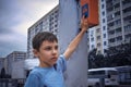 Little 7 years schoolboy pressing a button on traffic lights and waiting for green light Royalty Free Stock Photo