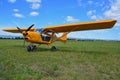 Little yellow airplane on green grass field