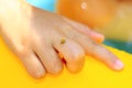 Little yellow ladybug sits on the child`s hand on a bright summer day