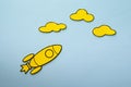 Little yellow rocket flying high aiming for clouds