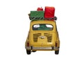 Little yellow vintage car with red, green and yellow gift boxes on its roof rear view isolated Royalty Free Stock Photo