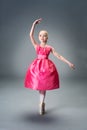 Little young ballerina girl in pink dress doing gymnastic split. Royalty Free Stock Photo