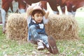 Little young cowboy laying in the hay