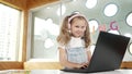 Little young cute girl using laptop to working or playing games. Erudition. Royalty Free Stock Photo