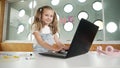 Little young cute girl using laptop to working or playing games. Erudition. Royalty Free Stock Photo