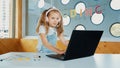 Little young cute girl using laptop to working or playing games. Erudition. Royalty Free Stock Photo