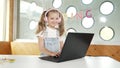 Little young cute girl using laptop to working or playing games. Erudition. Royalty Free Stock Photo