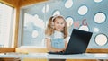 Little young cute girl using laptop to working or playing games. Erudition. Royalty Free Stock Photo