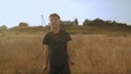 Little young dreamy boy walking in the picteresque field beautiful landscape yellow grass