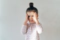 little young girl with her hair gathered on top posing for a portrait in natural light with a disturbed crying expression, by Royalty Free Stock Photo