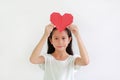 Little young girl kid show red heart sign holding over head against white background Royalty Free Stock Photo