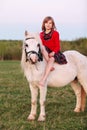 Little young girl sitting astride a white horse and smiling Royalty Free Stock Photo