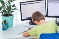 Little young school boy working at home with a laptop and class notes studying in a virtual class. Distance education and learning Royalty Free Stock Photo