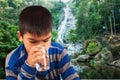 Littleboy drinking water on nature background