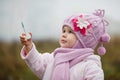 A littlegirl blows bubbles in autumn