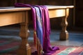 a liturgical stole draped over a wooden stool