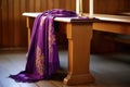 a liturgical stole draped over a wooden stool