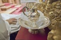 Liturgical wash basin and pitcher beside a sitting priest