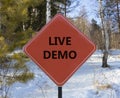 Live demo symbol. Concept words Live demo on beautiful red road sign. Beautiful forest snow blue sky background. Copy space. Royalty Free Stock Photo