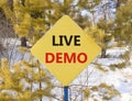 Live demo symbol. Concept words Live demo on beautiful yellow road sign. Beautiful forest snow blue sky background. Copy space. Royalty Free Stock Photo