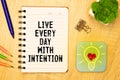 Live every day with intention. Words written under torn paper. Motivation concept text