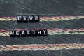 Live Healthy on wooden blocks. Cross processed image with blackboard background.