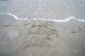 Live Laugh Love phrase written on the beach in the sand as the ocean waves roll in