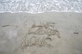 Live Laugh Love phrase written on the beach in the sand as the ocean waves roll in