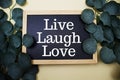 Live Laugh Love text message with eucalyptus leaf decoration on pink and blue background Royalty Free Stock Photo