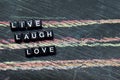 Live Laugh Love on wooden blocks. Cross processed image with blackboard background. Royalty Free Stock Photo