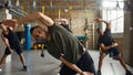 Live life, love fitness. Athletic caucasian man in sportswear smiling at camera while working out in industrial gym